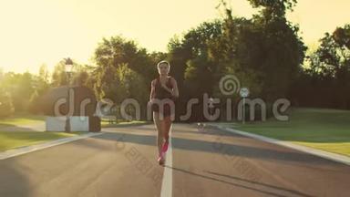 日落时分在公园里跑步的运动女子。 女子跑步训练户外运动